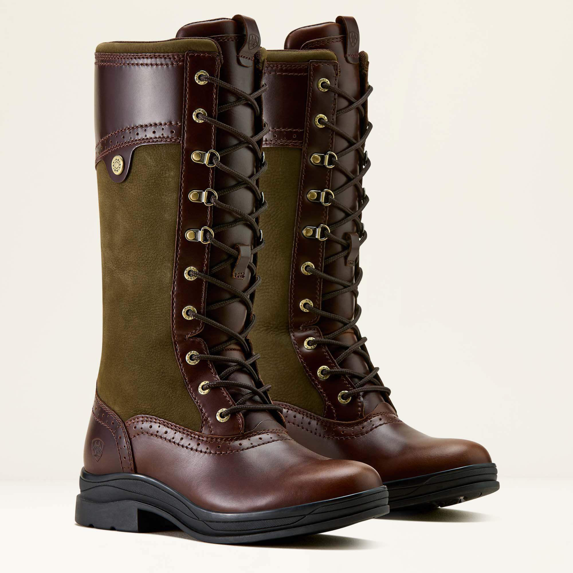 Pair of Ariat Wythburn II Waterproof brown and green boots with laces on a beige background