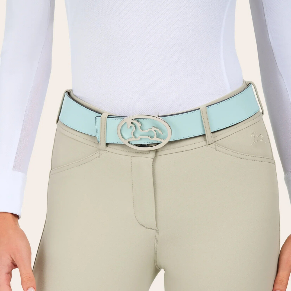 Image of R.J. Classics aqua reversible Bobbie belt with a metal R.J. Logo belt buckle on a model wearing beige breeches & a white show shirt.