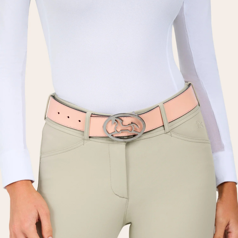 Image of R.J. Classics blush reversible Bobbie belt with a metal R.J. Logo belt buckle on a model wearing beige breeches & a white show shirt.
