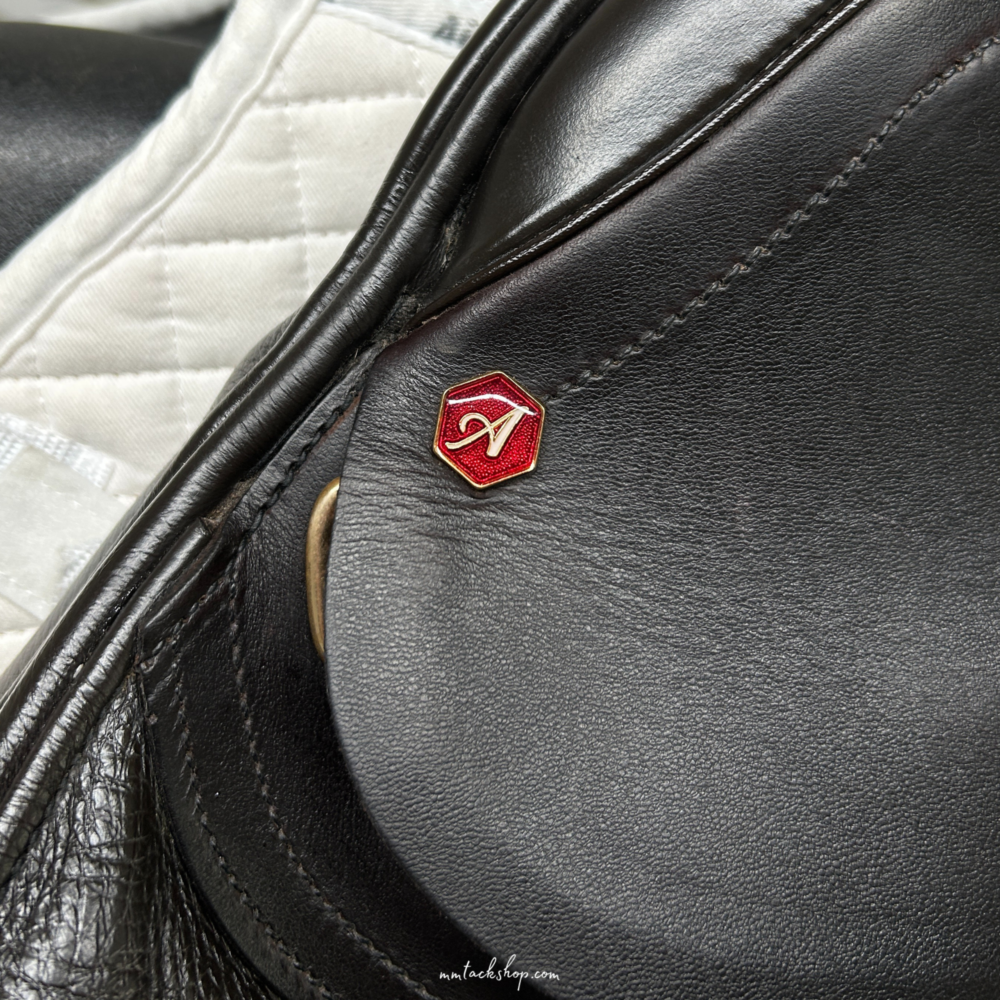 Close up of the near side head pin on a dark Havana demo Albion 17.5" flat forward, medium wide jump saddle.