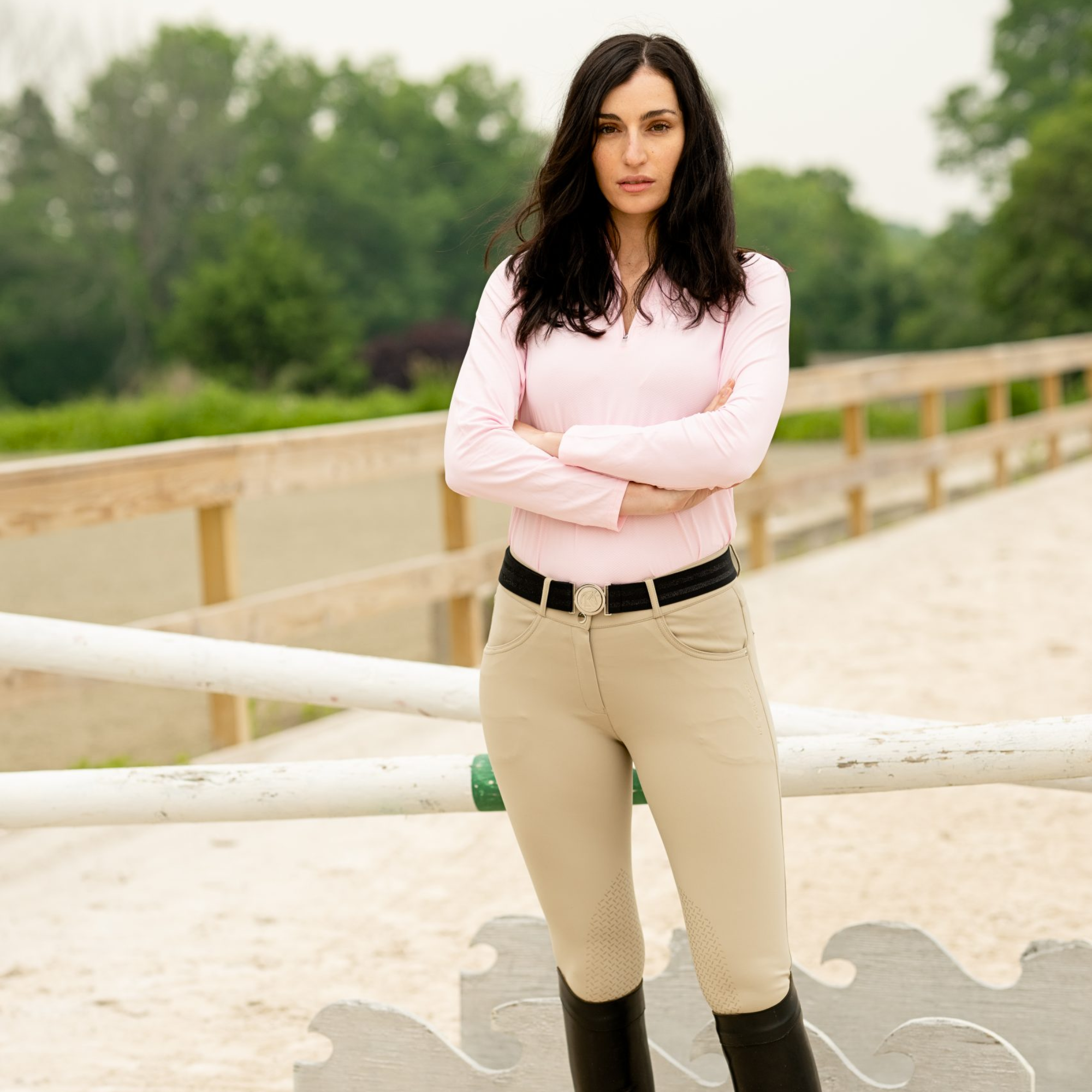 Woman in equestrian attire standing in a stable
