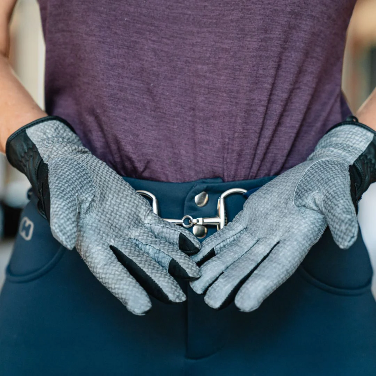 Person wearing gray gloves with black accents, holding out the palms.
