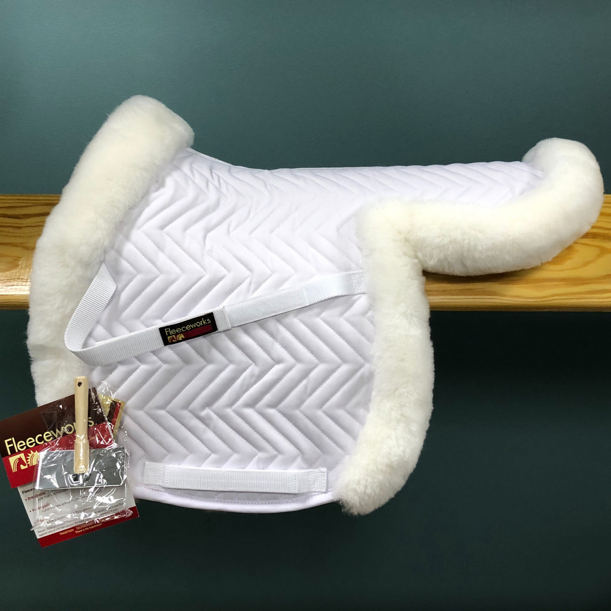 A white Fleeceworks Perfect Balance Show Hunter Pad with partial trim, featuring quilted design and sheepskin material.