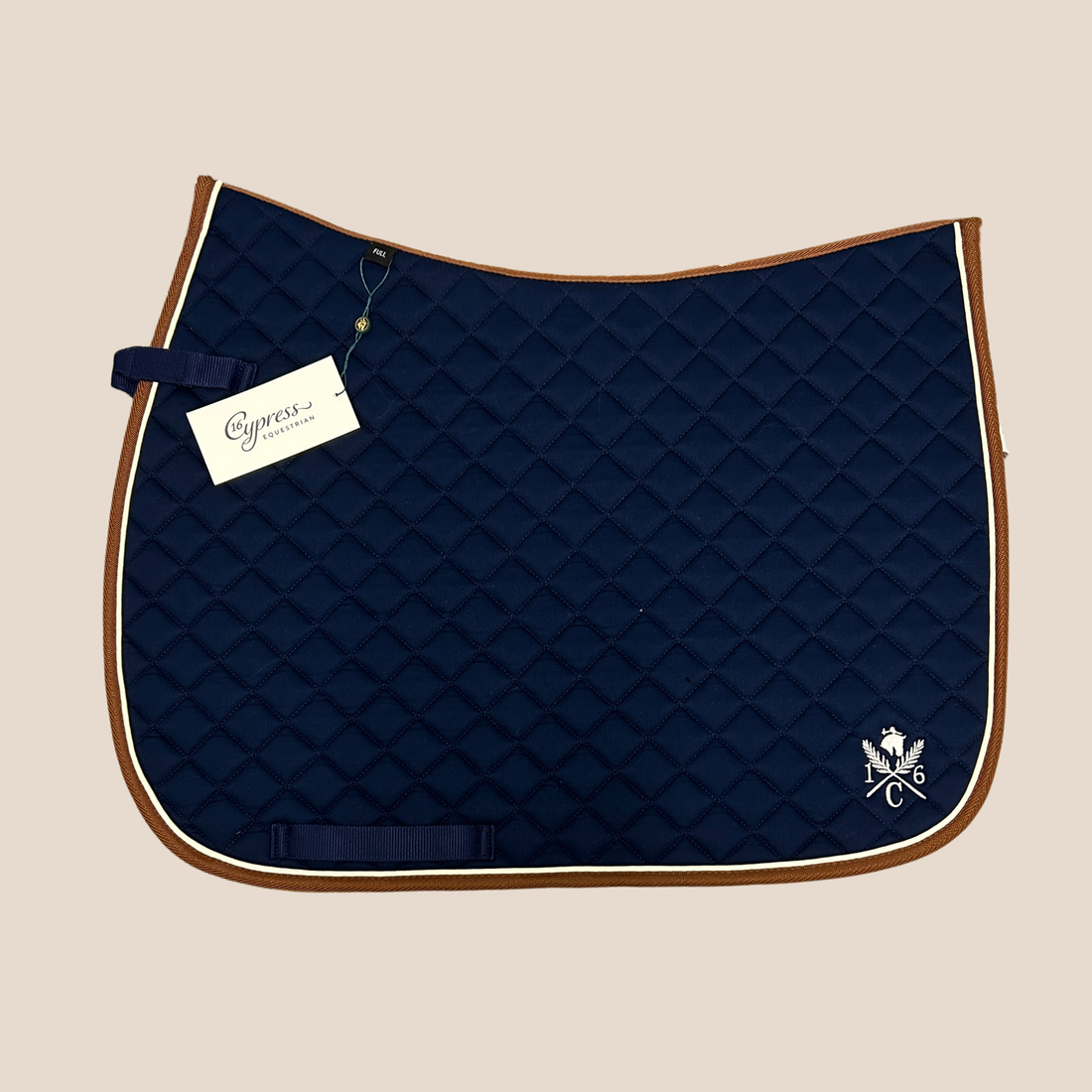 Navy 16 Cypress Daily Sport Jumper quilted saddle pad with brown edges &amp; beige piping on a beige background
