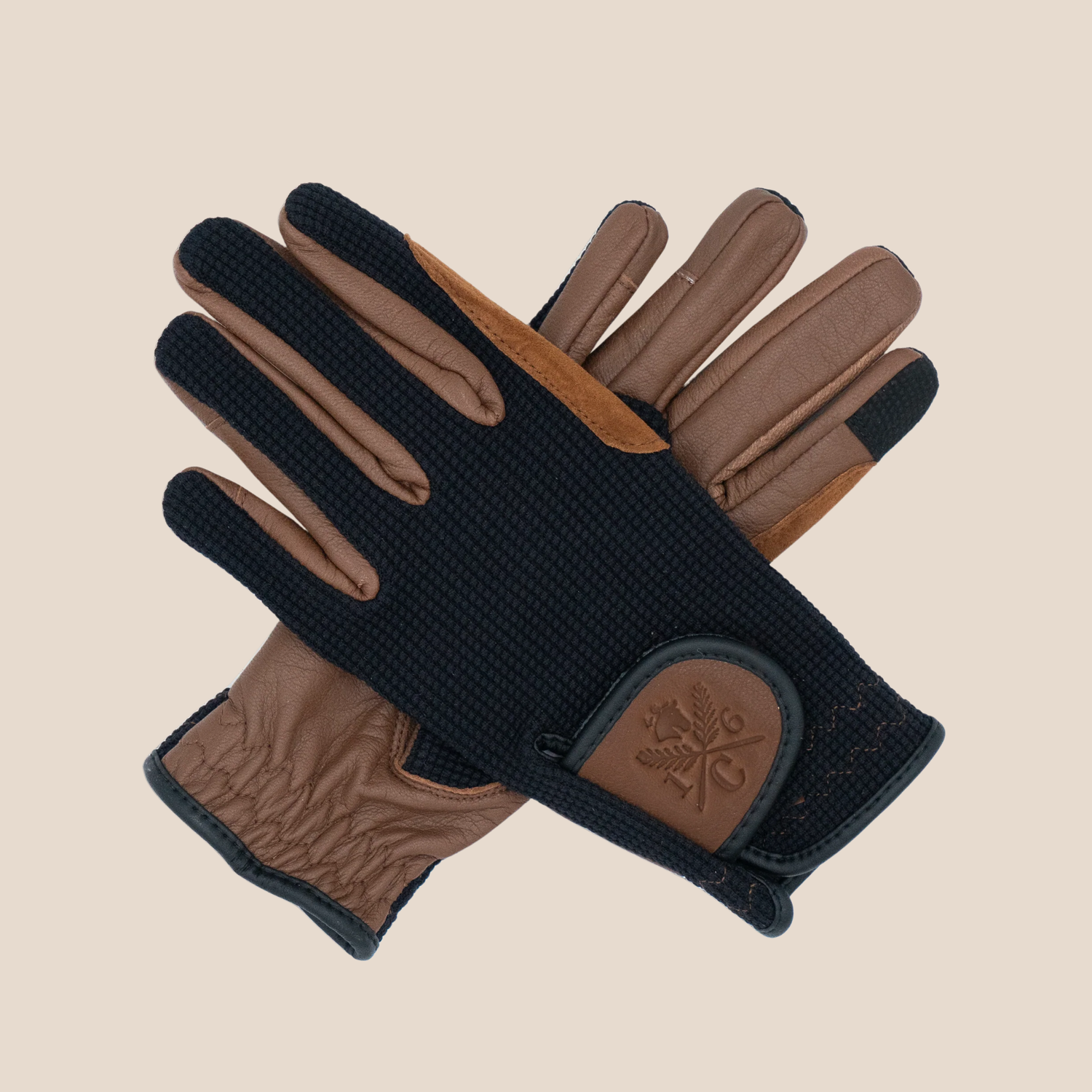A pair 16 Cypress riding gloves in black and cognac, arranged in an overlapping flat-lay composition on a solid light beige background.