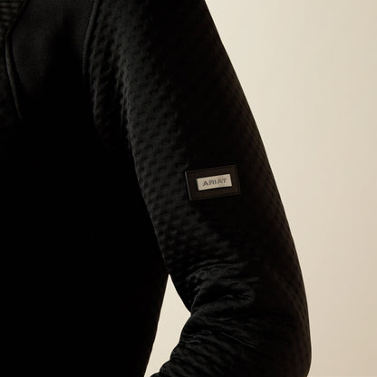 Ariat Radiance Full Zip black jacket sleeve with a brand label on a beige background