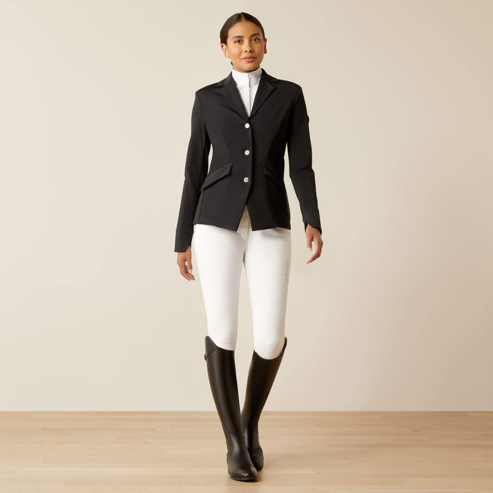 Full body image of Ariat's Meridian X black show coat on a model wearing tall boots, white riding breeches and a white show shirt.