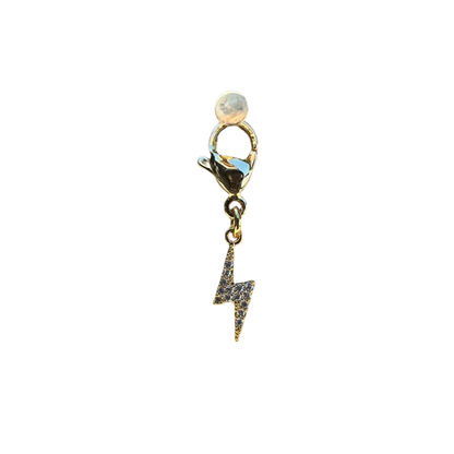 Gold charm with a lightning bolt design on a white background