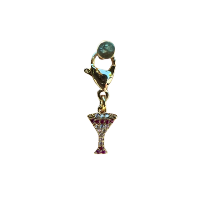 Gold charm shaped like a cocktail glass with gemstones on a white background