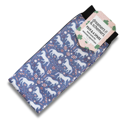 Dreamers &amp; Schemers The Pony Island "Peppermint Ponies" boot socks with a blue, white, and red holiday pattern of ponies, candy canes, and snowflakes, featuring a paper tag that reads &
