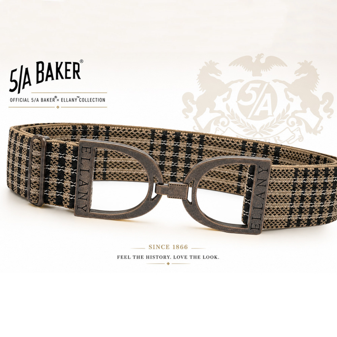 A 5/A Baker x Ellany collection elastic belt with a black and beige plaid pattern and copper metal stirrups buckle, displayed on a clean white background with Baker brand logos.
