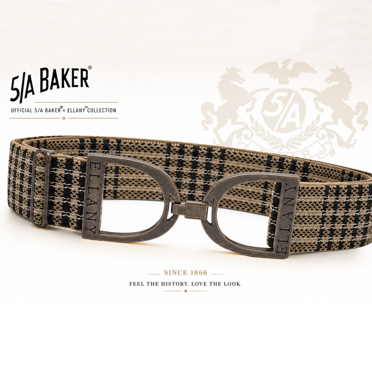 A 5/A Baker x Ellany collection elastic belt with a black and beige plaid pattern and copper metal stirrups buckle, displayed on a clean white background with Baker brand logos.