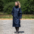 A woman wearing a navy blue EquiDry Evolution Mesh Lined  hooded raincoat with a white &
