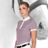 Woman wearing a mauve, short sleeve Fair Play Competition shirt with a image of a horse in the background.