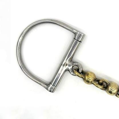 Closeup of the cheekpiece of a Jake Adams Equestrian Brass Waterford D bit on a white background.