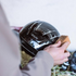 Person cleaning a black KASK helmet with KASKs Helmet Cleaning Kit sponge against a neutral background