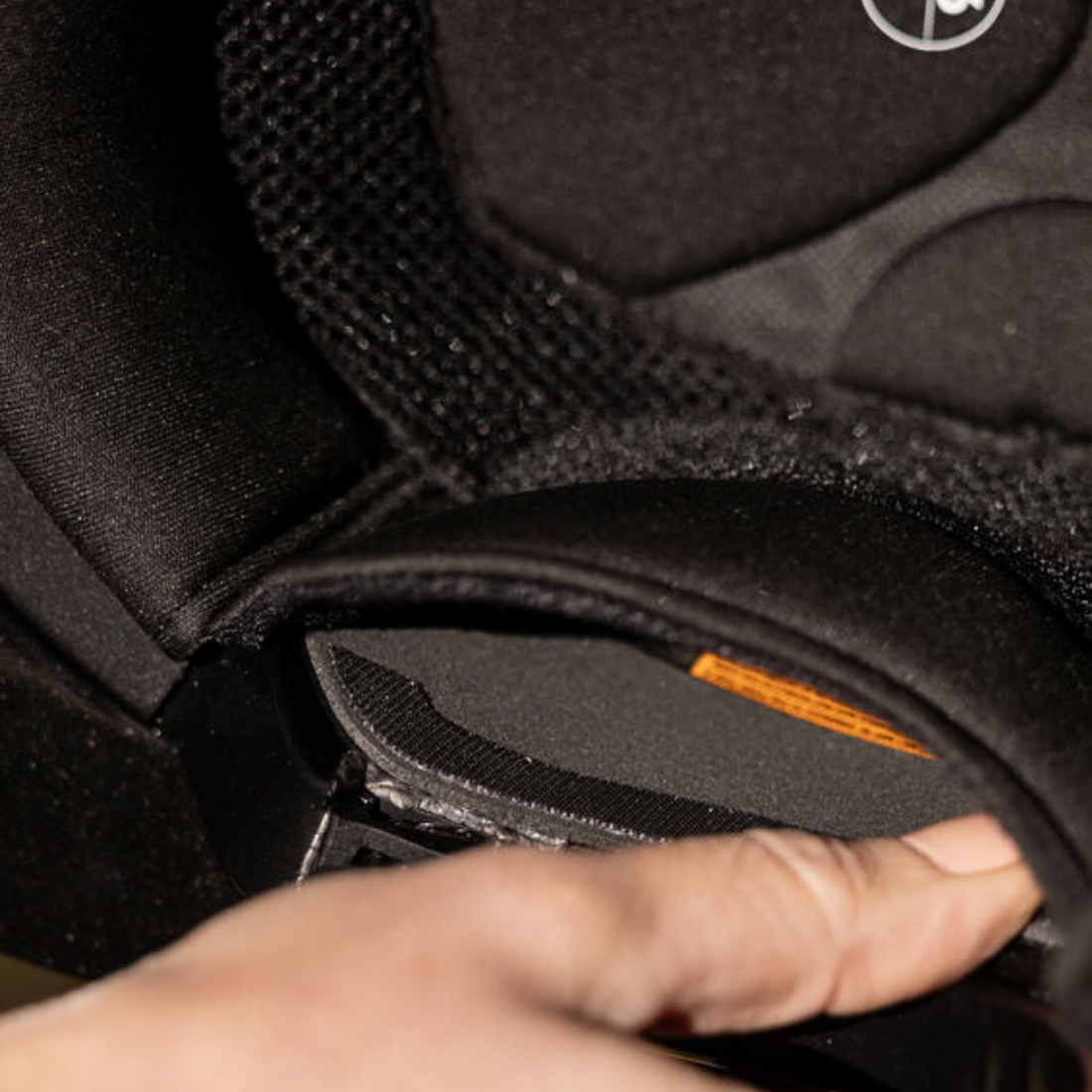 Close-up of a hand adjusting the KASK lateral inserts inside a KASK riding helmet.