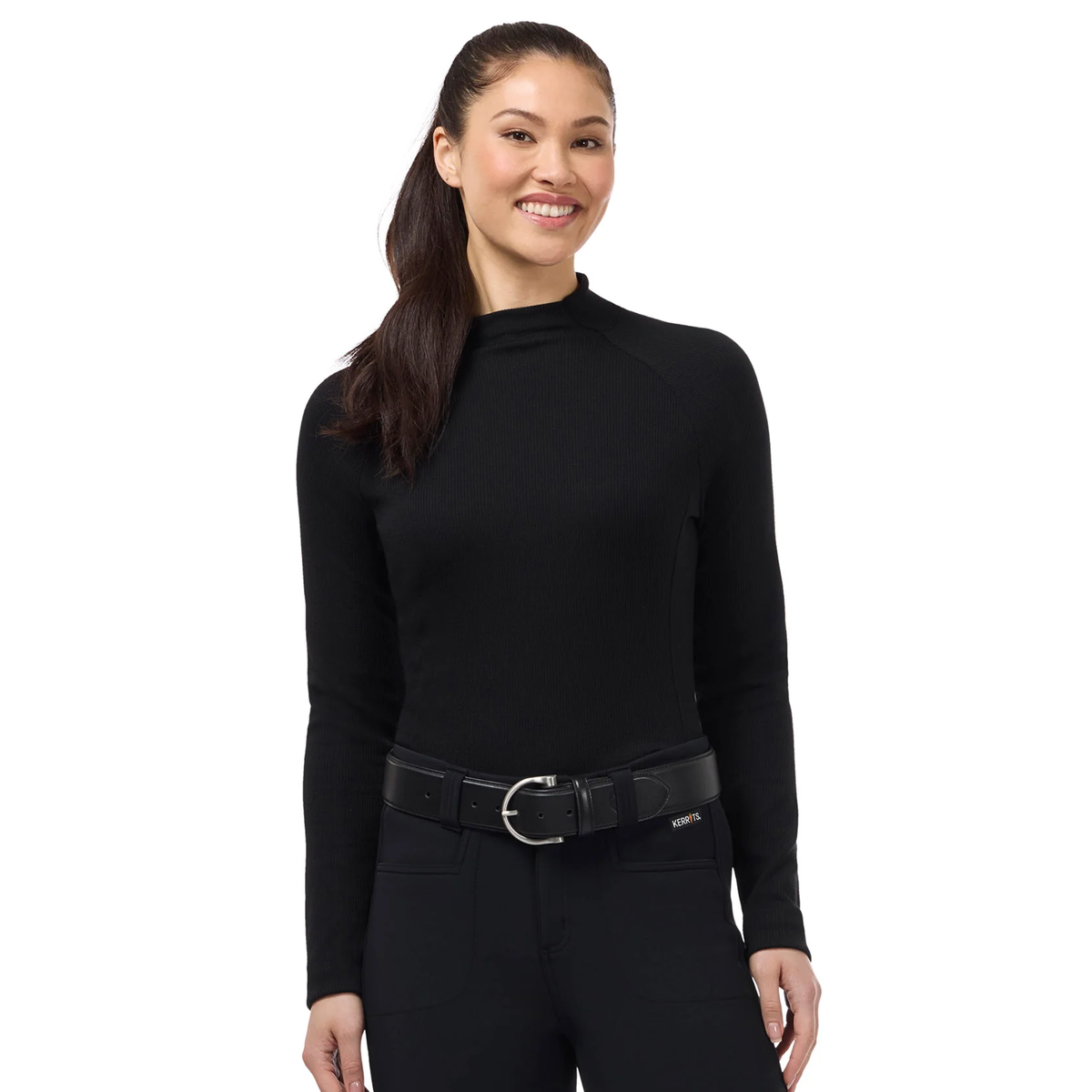 A woman modeling a black Kerrits Align Textured black long-sleeve mock neck top with raglan sleeves and  a black belt, photographed against a solid white background.