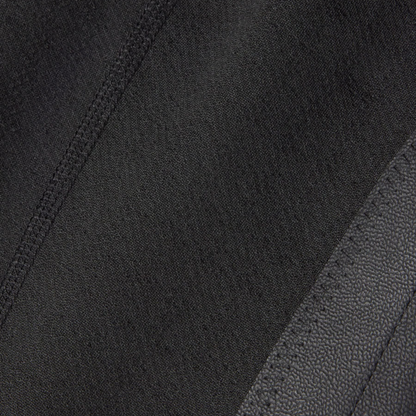 Close-up of Kerrits black Kids Fleece Lite II Knee Patch Riding Tights fabric with a diagonal seam and black pebbled leather-like grip.
