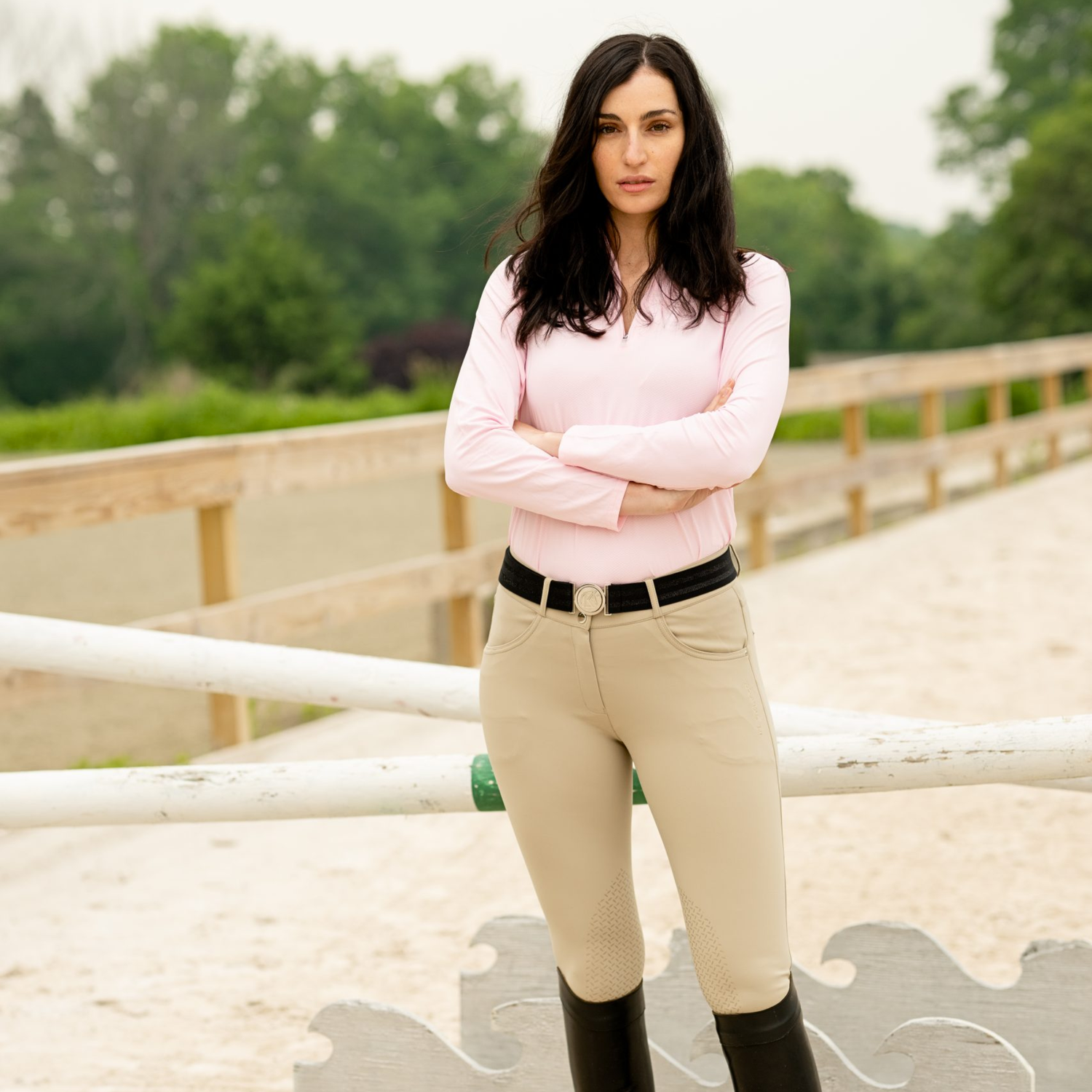 Woman in equestrian attire standing in a stable