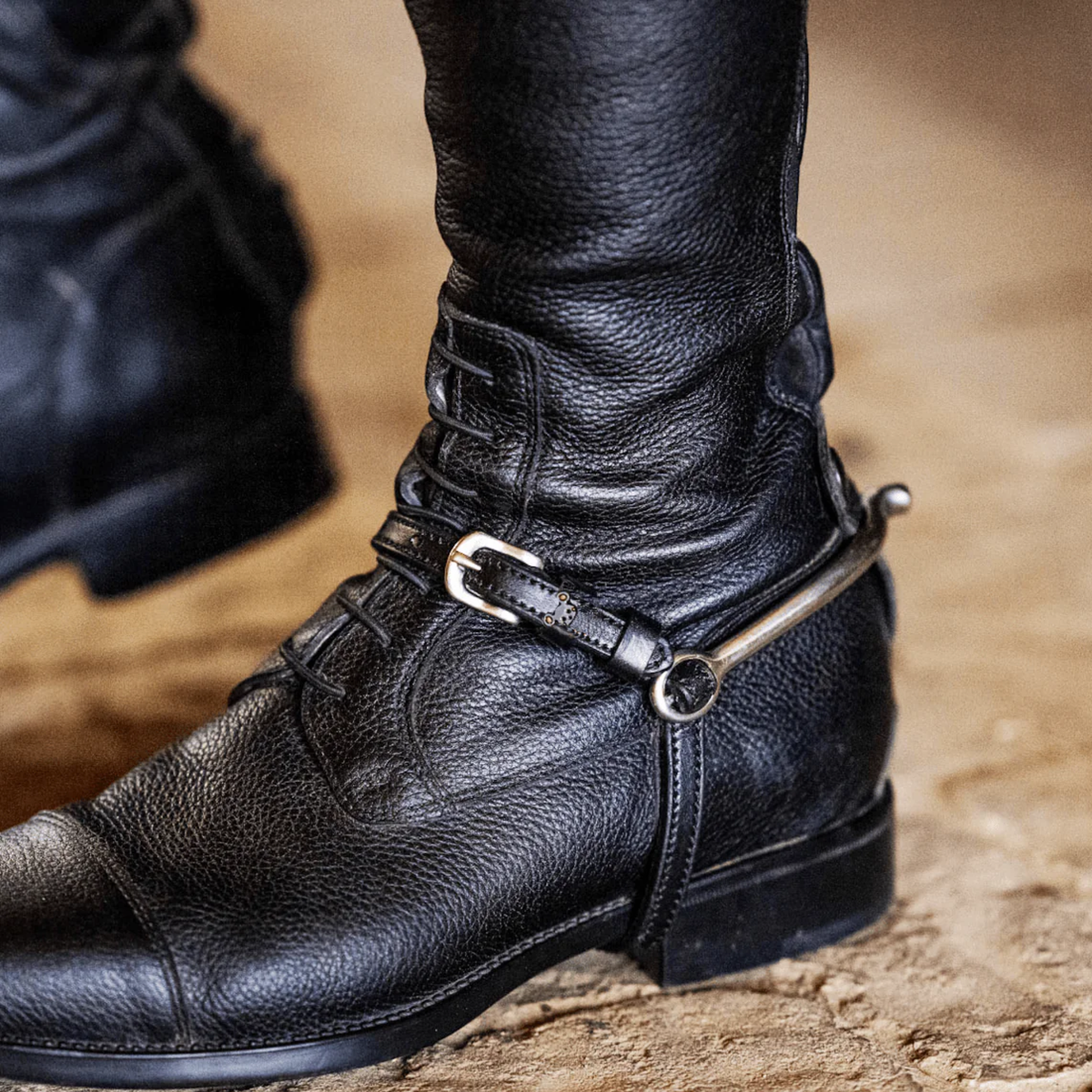 Mane Jane Mouse charm spur straps on a riding boot.