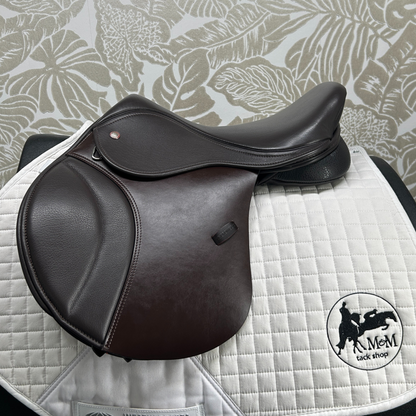 Thorowgood 15.5" T9 Pony Jump saddle on a quilted white saddle pad with a patterned gray background.
