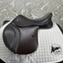 Thorowgood 15.5" T9 Pony Jump saddle on a quilted white saddle pad with a patterned gray background.