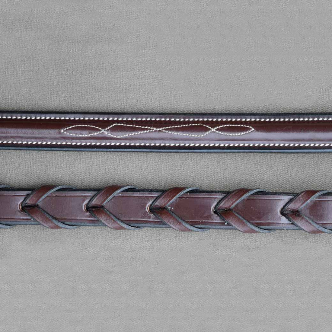 A close up detail of kl select black oak round raised fancy laced reins. 